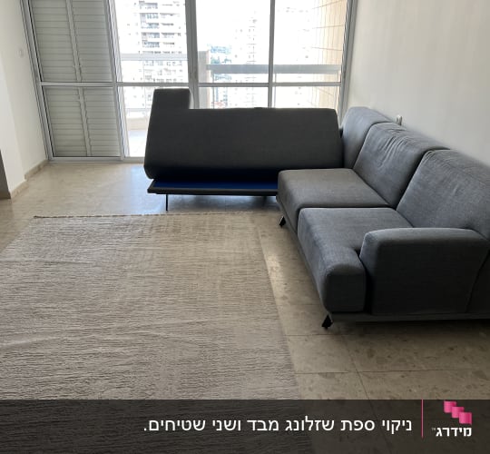 ספה אפורה בחדר עם שטיח בהיר